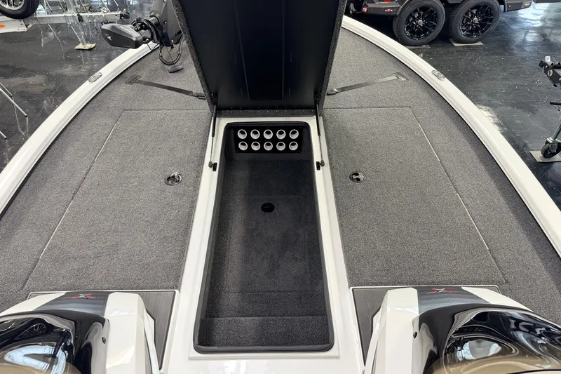 Slide: The Image of 2026 Vexus AVX 1985s boat interior with open storage compartment and carpeted deck. - 19