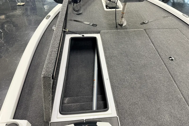 Slide: The Image of 2026 Vexus AVX 1985s boat interior with open storage compartment and carpeted deck. - 22