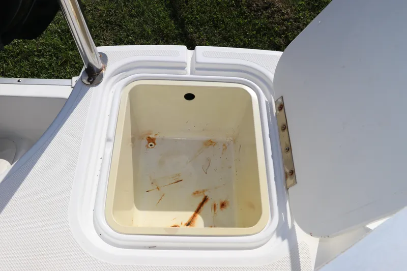 Slide: The Image of Open storage compartment on 2016 Hurricane SunDeck 2486 OB boat, showing interior details. - 12