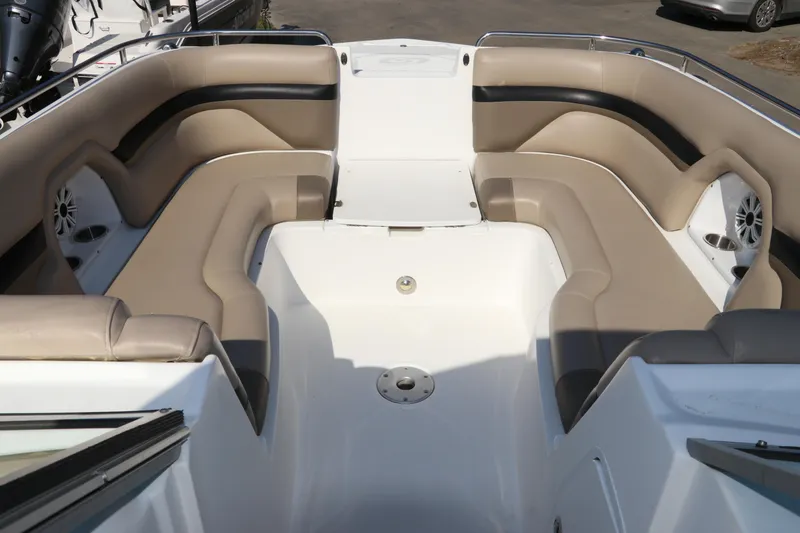 Slide: The Image of 2016 Hurricane SunDeck 2486 OB boat interior with beige seating and cup holders. - 23