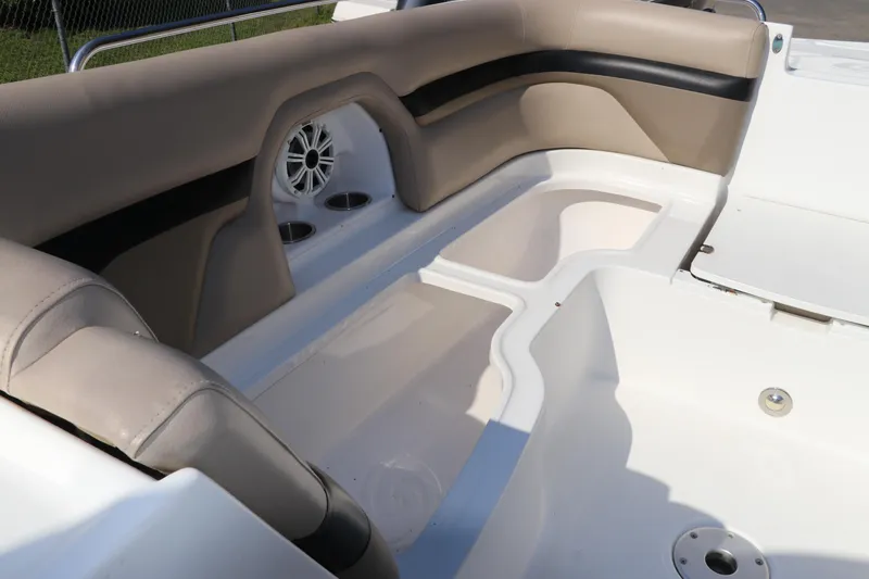 Slide: The Image of 2016 Hurricane SunDeck 2486 OB boat interior with beige seating and built-in cup holders. - 27