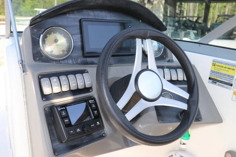Slide: The Image of 2016 Hurricane SunDeck 2486 OB boat dashboard with steering wheel and control panel. - 28