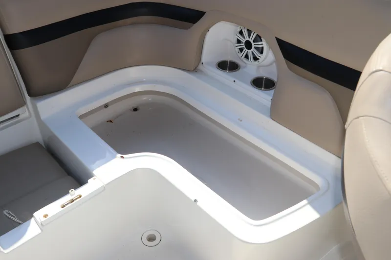 Slide: The Image of 2016 Hurricane SunDeck 2486 OB boat interior with storage compartment and cup holders. - 29