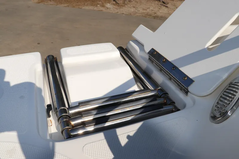 Slide: The Image of 2016 Hurricane SunDeck 2486 OB boat ladder, stainless steel, folded on deck. - 35