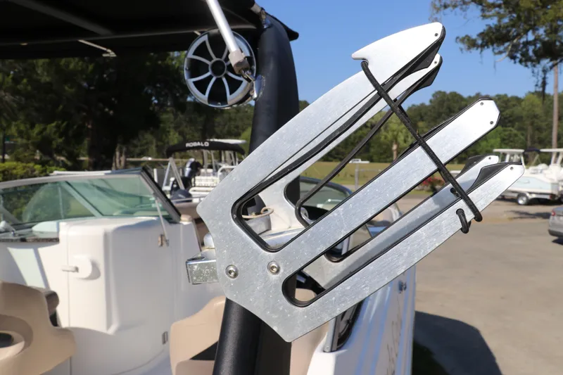 Slide: The Image of 2016 Hurricane SunDeck 2486 OB boat with wakeboard rack and speaker, docked outdoors. - 36