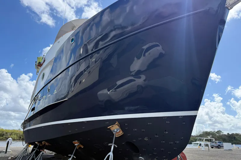 Slide: The Image of A 1997 Real Ships 61' Islander yacht on dry dock with an American flag. - 2