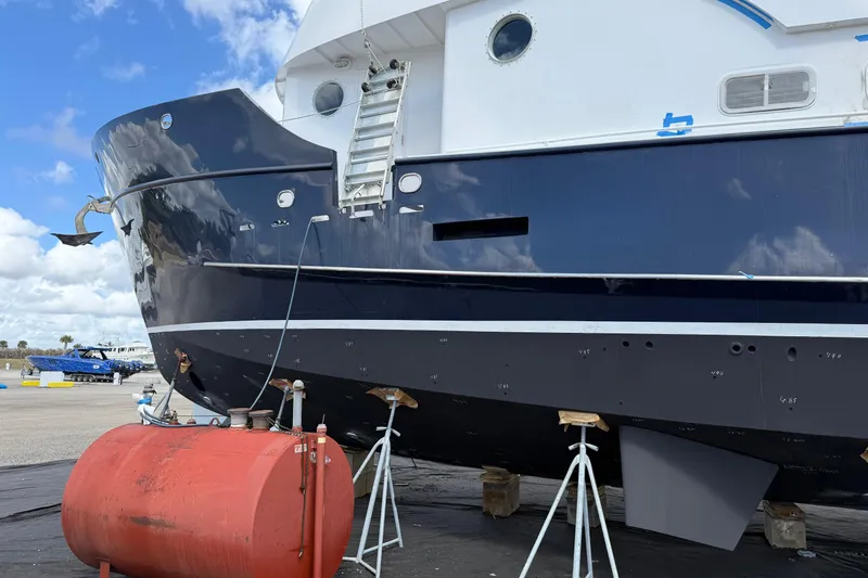 Slide: The Image of 1997 Real Ships 61' Islander yacht on dry dock, blue hull, maintenance equipment visible. - 37