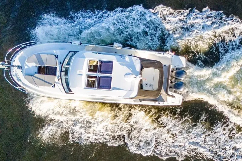 Slide: The Image of Aerial view of 2021 Jeanneau NC 1095 motorboat cruising through water. - 16