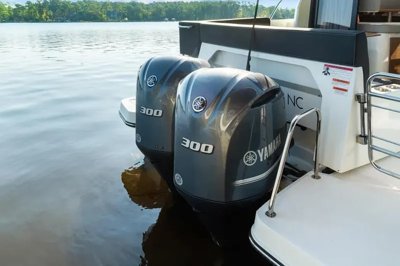 Slide: The Image of 2021 Jeanneau NC 1095 with twin Yamaha 300 outboard engines on a serene lake. - 18