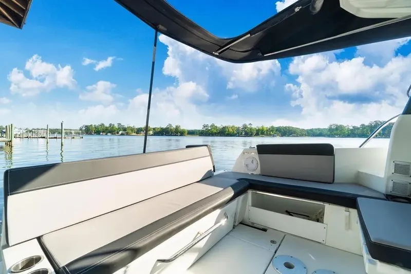 Slide: The Image of 2021 Jeanneau NC 1095 boat interior with seating, overlooking serene lake and blue sky. - 19