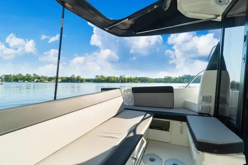 Slide: The Image of 2021 Jeanneau NC 1095 boat interior with seating, overlooking serene lake and blue sky. - 20