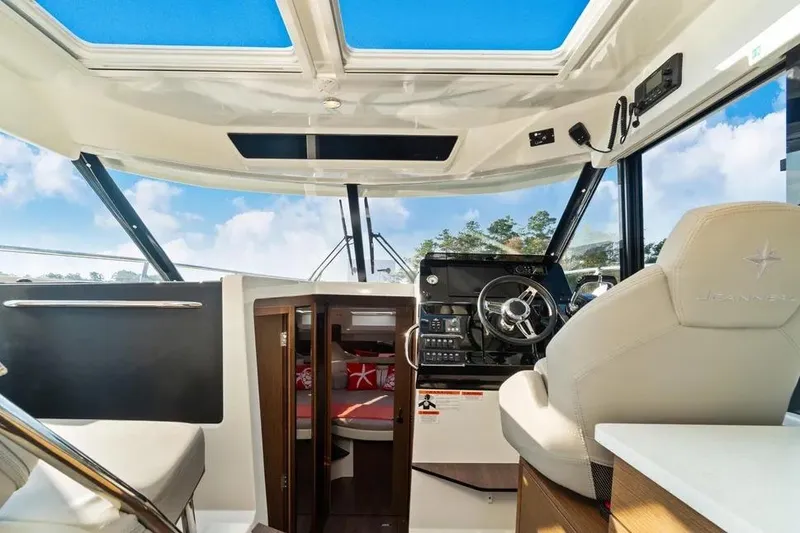 Slide: The Image of Interior view of 2021 Jeanneau NC 1095 boat cockpit with steering wheel and seating. - 23