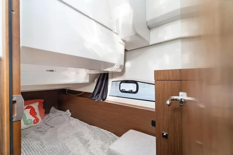 Slide: The Image of Cozy cabin interior of 2021 Jeanneau NC 1095 boat with bed and window. - 24