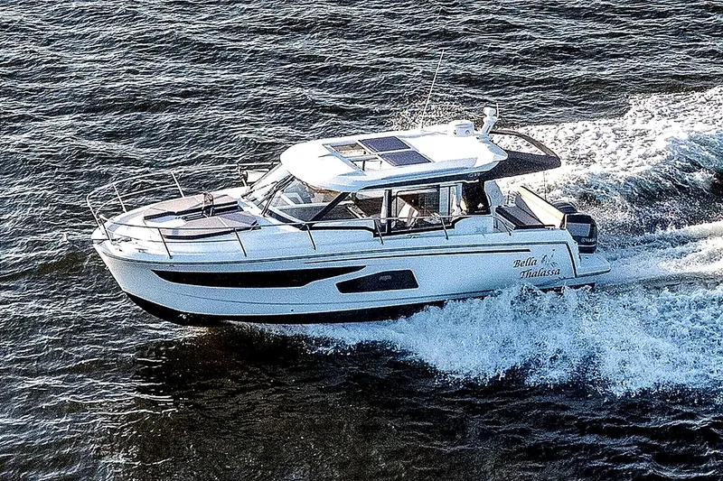 Slide: The Image of 2021 Jeanneau NC 1095 motor yacht cruising on open water. - 5