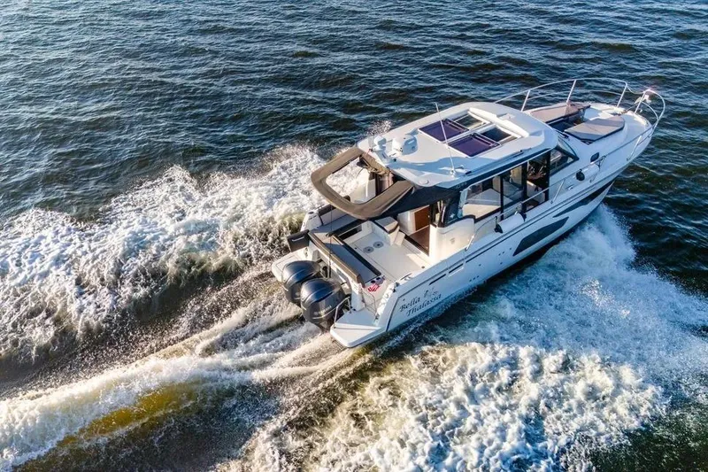 Slide: The Image of 2021 Jeanneau NC 1095 cruising on open water, creating a dynamic wake. - 8