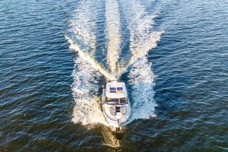 Slide: The Image of 2021 Jeanneau NC 1095 cruising on open water, aerial view. - 9