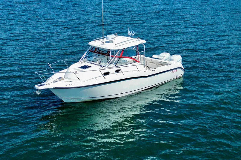 Slide: The Image of 2005 Boston Whaler 305 Conquest boat on open water, showcasing sleek design and spacious deck. - 1