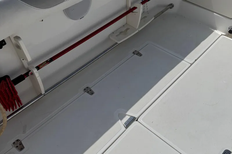 Slide: The Image of 2005 Boston Whaler 305 Conquest deck with storage compartments and cleaning tools. - 27
