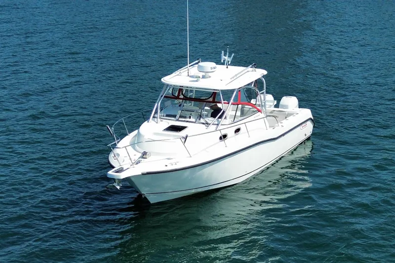 Slide: The Image of 2005 Boston Whaler 305 Conquest boat on calm blue water. - 3