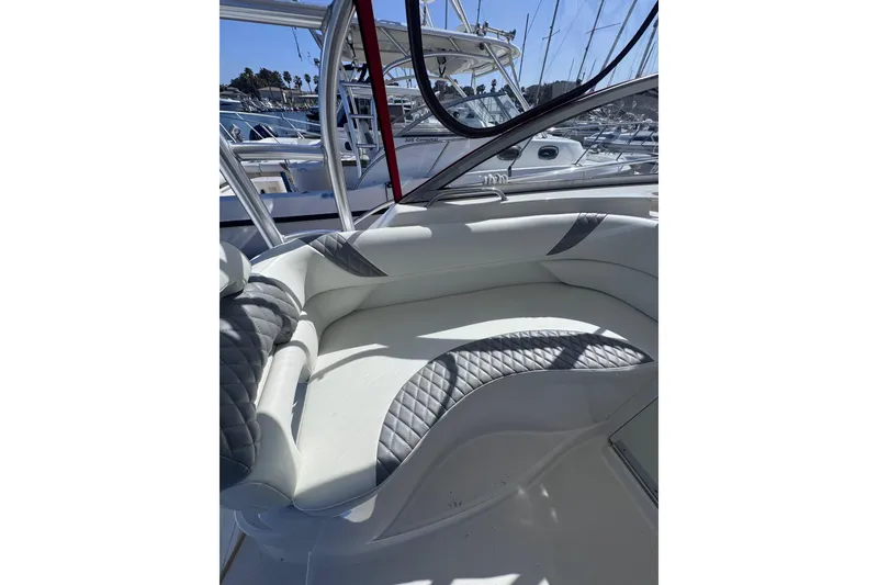 Slide: The Image of 2005 Boston Whaler 305 Conquest interior seating with quilted upholstery in a marina setting. - 43