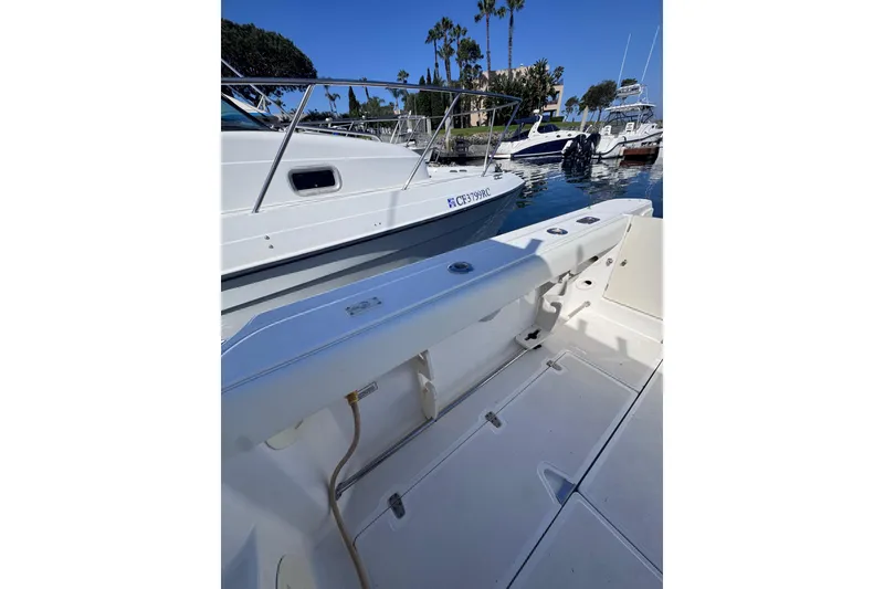 Slide: The Image of 2005 Boston Whaler 305 Conquest docked, showcasing spacious deck and sleek design. - 45