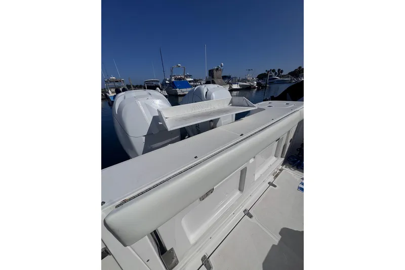 Slide: The Image of 2005 Boston Whaler 305 Conquest boat docked, showcasing dual engines and spacious deck. - 46