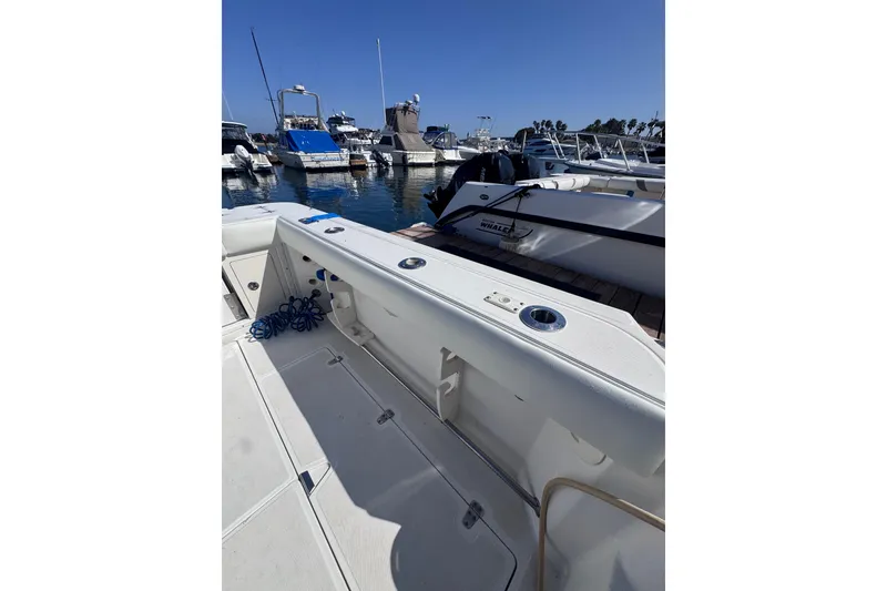Slide: The Image of 2005 Boston Whaler 305 Conquest docked at marina, showcasing spacious deck and sleek design. - 47