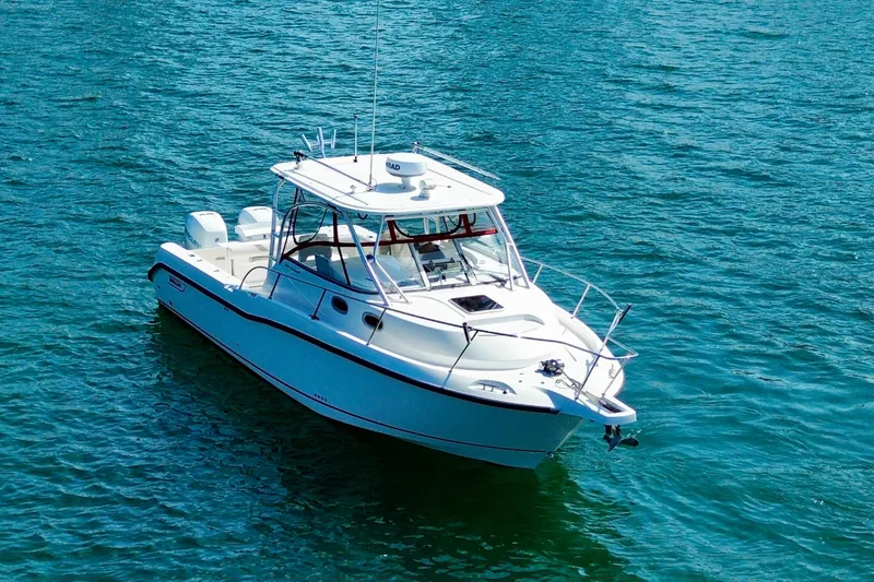 Slide: The Image of 2005 Boston Whaler 305 Conquest boat on clear blue water. - 7