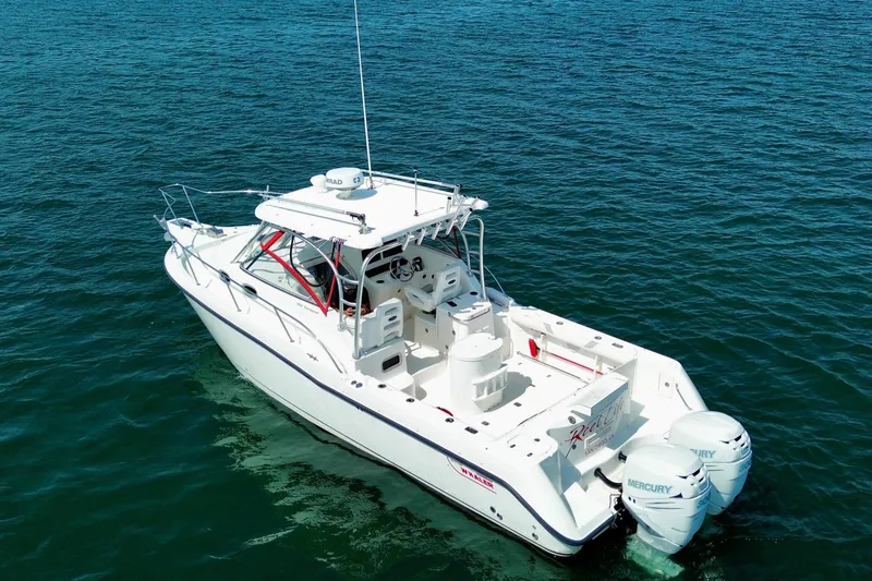 Slide: The Image of 2005 Boston Whaler 305 Conquest boat on open water, featuring twin Mercury engines. - 8