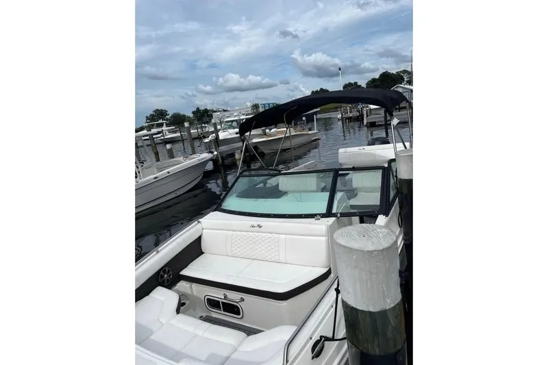 Slide: The Image of 2019 Sea Ray SDX 250 Outboard boat docked at marina under cloudy sky. - 3
