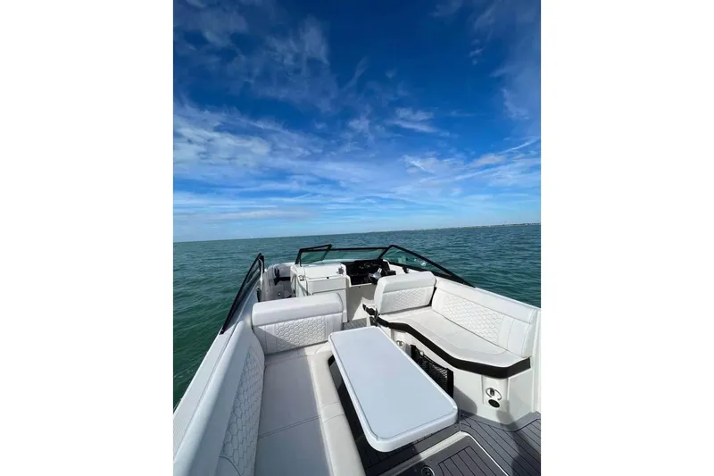 Slide: The Image of 2019 Sea Ray SDX 250 Outboard boat interior with seating, on open water under blue sky. - 7