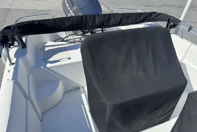 Slide: The Image of 2011 Carolina Skiff 218 DLV boat interior with Yamaha engine, featuring covered seating and console. - 11