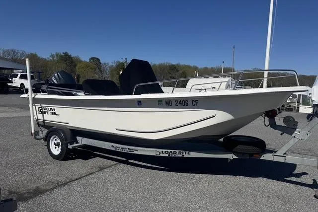 The Image of 2011 Carolina Skiff 218 DLV boat on Load Rite trailer in parking lot. - 0