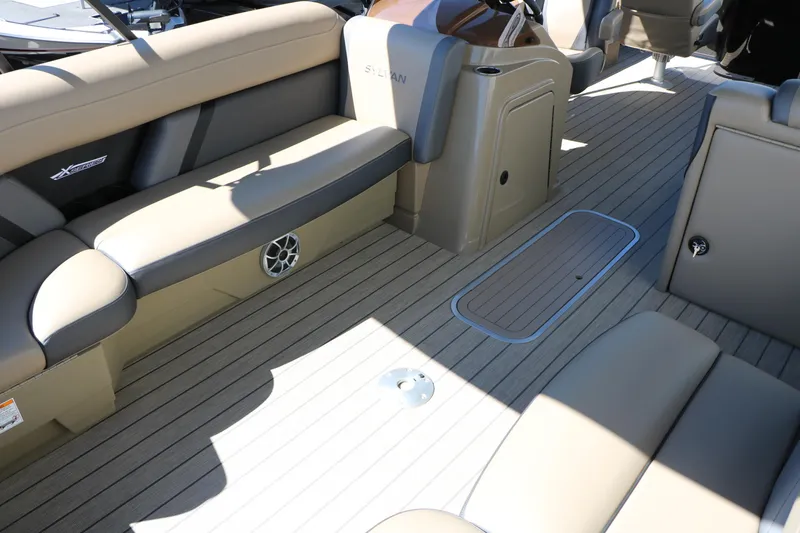 Slide: The Image of 2026 Sylvan Mirage X3 Party Fish boat interior with beige seating and wood-style flooring. - 17