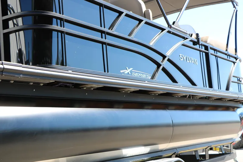 Slide: The Image of 2026 Sylvan Mirage X3 Party Fish pontoon boat, sleek black exterior, close-up view. - 6