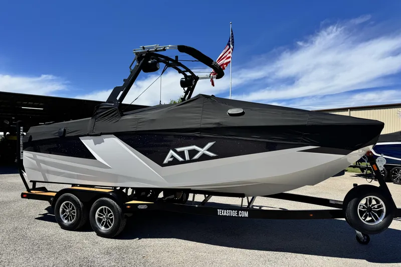 Slide: The Image of 2026 ATX Surf Boats 22 Type-S on trailer, covered, with American flag in background. - 15
