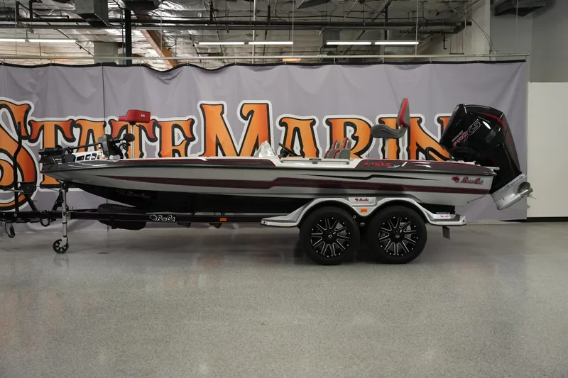 The Image of 2026 Bass Cat Lynx STS boat on trailer in showroom setting. - 1