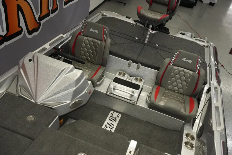 Slide: The Image of 2026 Bass Cat Lynx STS boat interior with gray and red seating, cup holders, and steering console. - 13