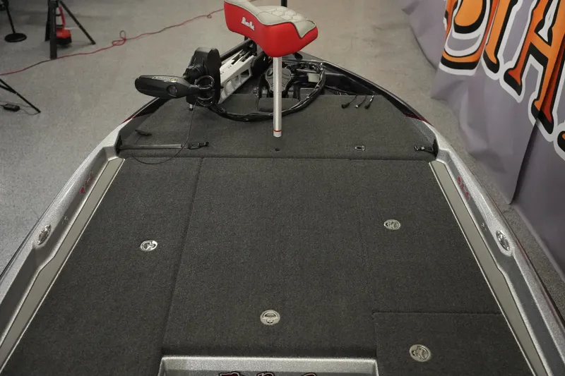 Slide: The Image of 2026 Bass Cat Lynx STS boat interior with carpeted deck and red seat. - 15