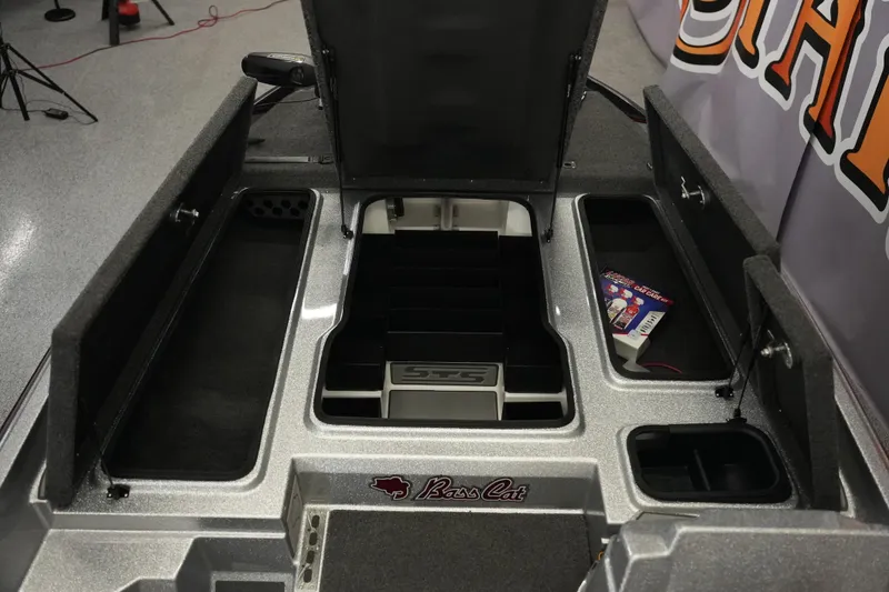 Slide: The Image of 2026 Bass Cat Lynx STS boat storage compartments with open lids and visible interior. - 16
