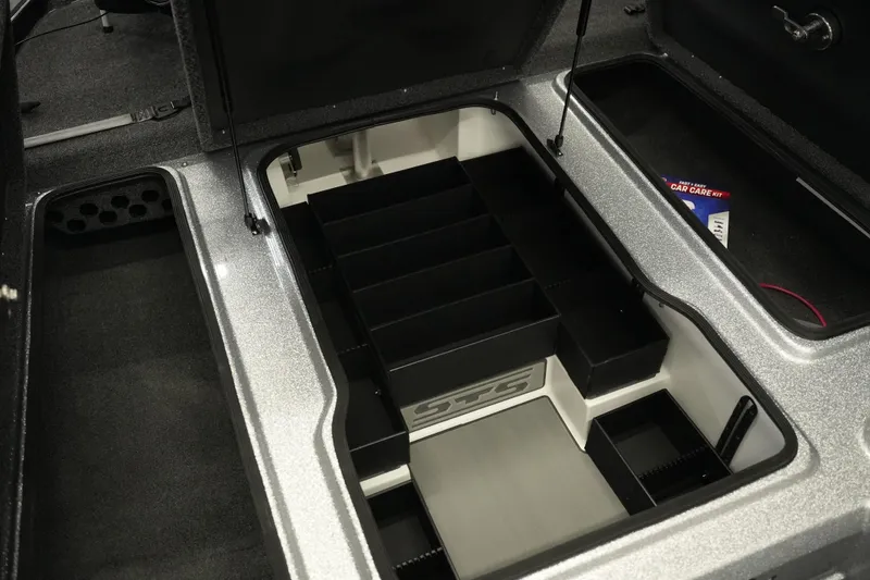 Slide: The Image of 2026 Bass Cat Lynx STS storage compartment with organized interior and car care kit. - 17