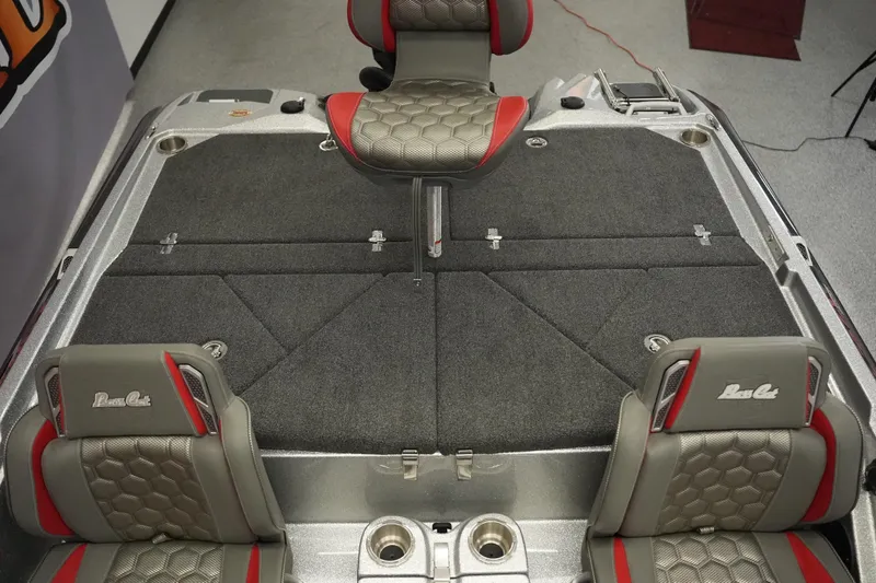Slide: The Image of 2026 Bass Cat Lynx STS boat interior with gray and red seating, spacious deck. - 19