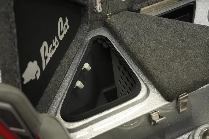 Slide: The Image of 2026 Bass Cat Lynx STS boat storage compartment with carpeted interior and logo. - 23