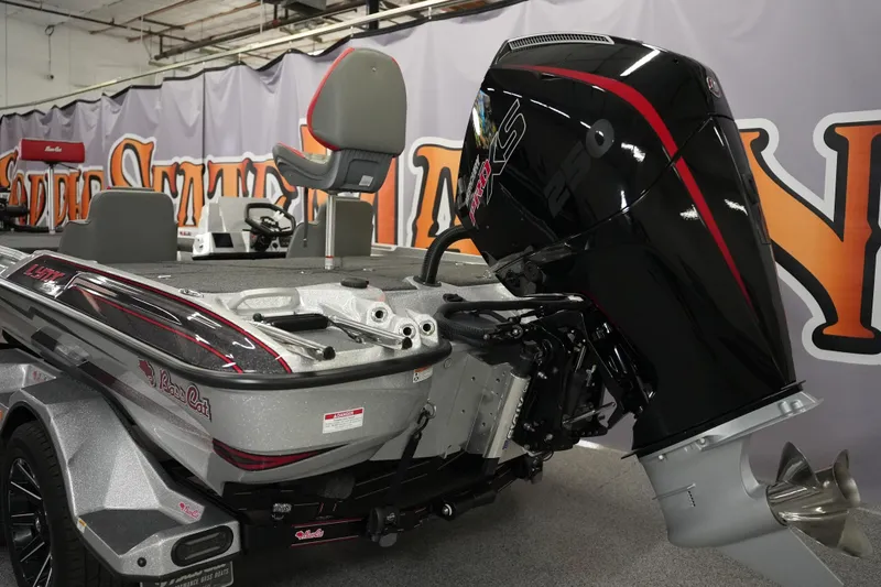 Slide: The Image of 2026 Bass Cat Lynx STS boat with powerful outboard motor in showroom setting. - 5