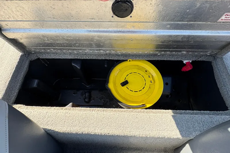 Slide: The Image of Storage compartment of a 2011 Tracker Pro Team 175 TXW boat with yellow lid. - 14