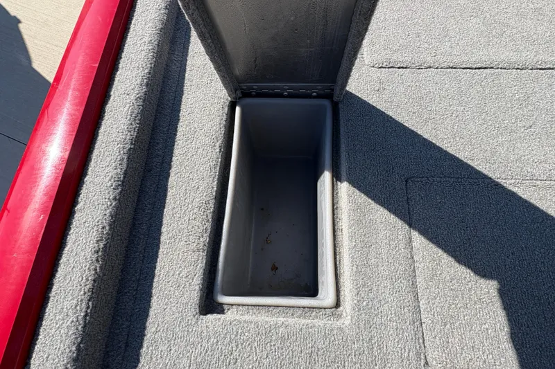 Slide: The Image of 2011 Tracker Pro Team 175 TXW boat storage compartment with gray carpet interior. - 16