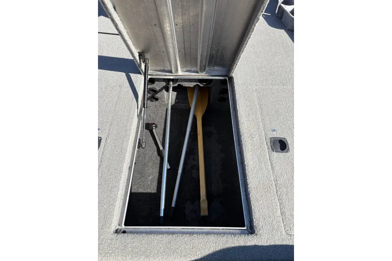 Slide: The Image of Open storage compartment in 2011 Tracker Pro Team 175 TXW boat with paddles and equipment. - 6