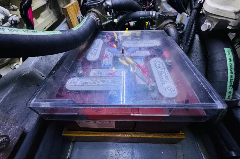 Slide: The Image of Battery compartment of a 1999 Sea Ray 400 Sedan Bridge, featuring cables and protective cover. - 101