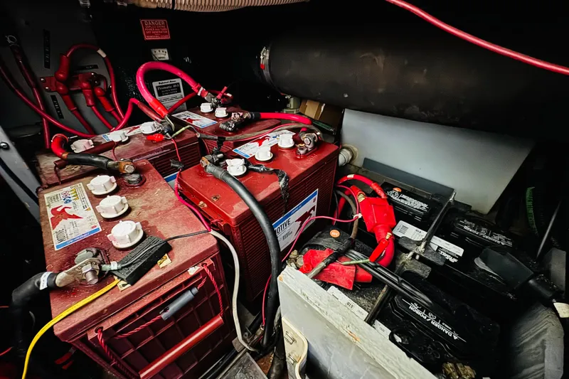 Slide: The Image of Battery compartment of a 1999 Sea Ray 400 Sedan Bridge with multiple connected batteries. - 102