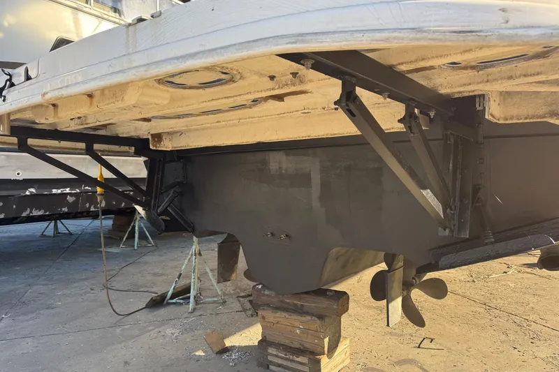 Slide: The Image of Underside view of a 1999 Sea Ray 400 Sedan Bridge on blocks, showing propeller and supports. - 106